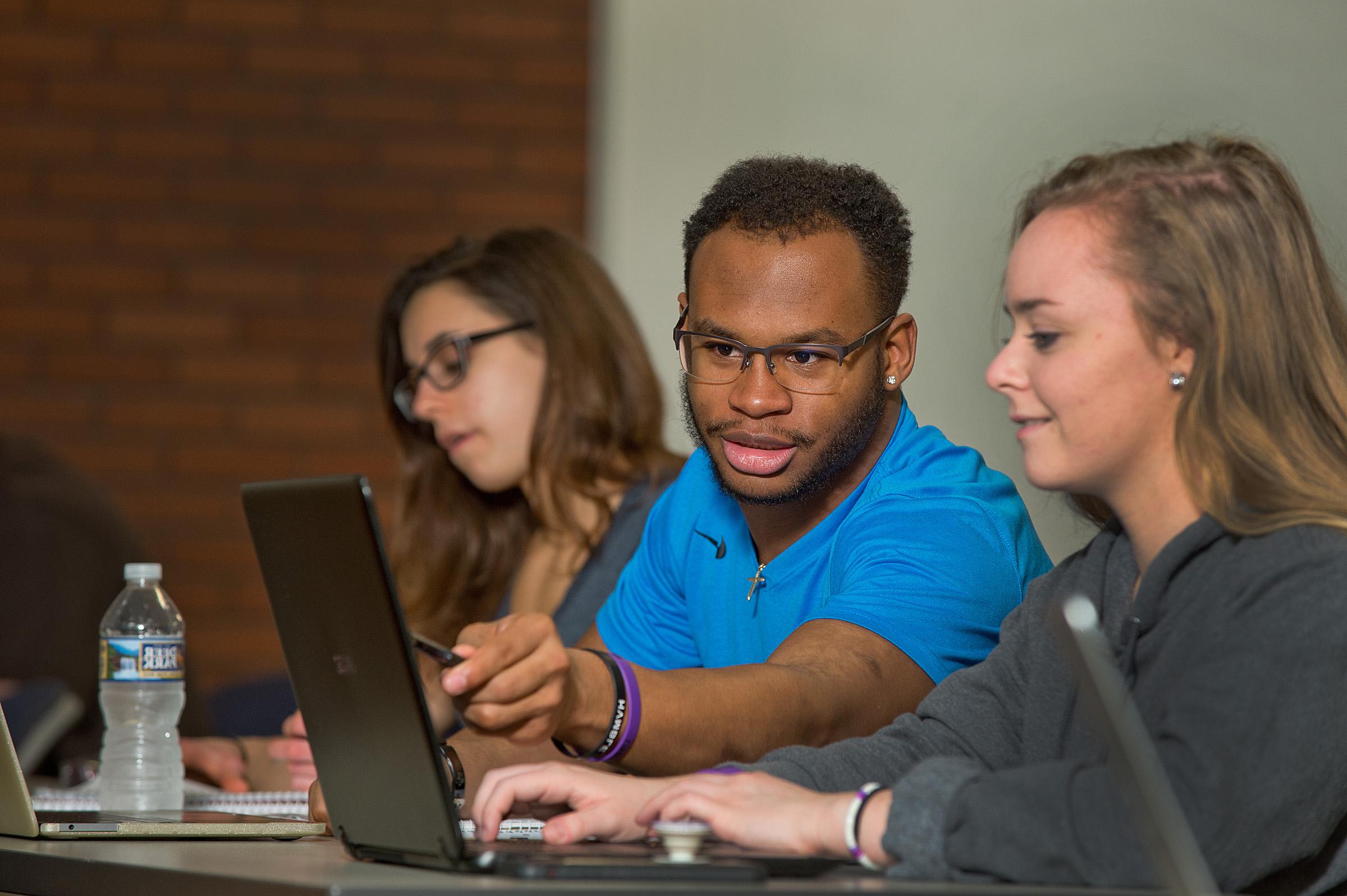 student pointing at computer 